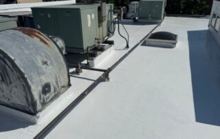 Rooftop view with HVAC units, pipes, and a vent on a flat white roof in Colorado Springs, suited for exterior home restoration.