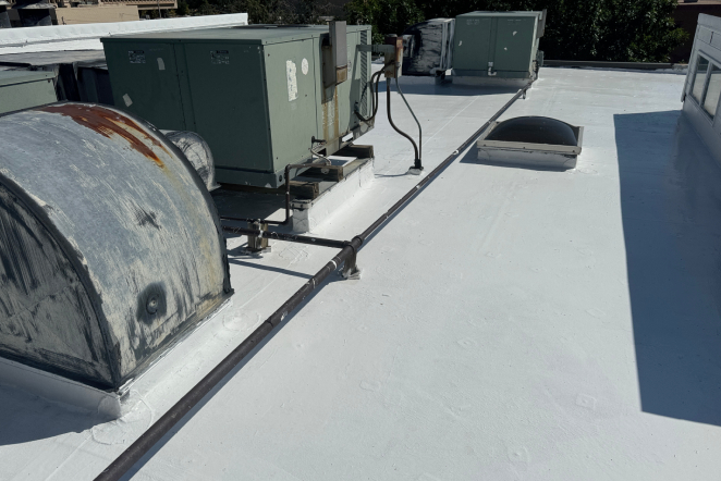 Commercial Roofing for Flat and Low-Slope Systems Rooftop view with HVAC units, pipes, and a vent on a flat white roof in Colorado Springs, suited for exterior home restoration.