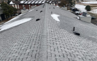 colorado springs roofing company View of a sloped gray shingle roof with snow patches and vents, ideal for Colorado Springs roofing or exterior restoration needs.