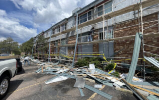 roofing company in colorado springs Construction materials and debris scattered outside a building with scaffolding during exterior restoration in Colorado Springs.